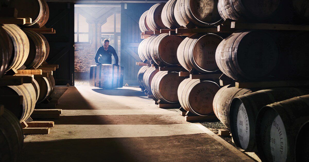 Man rolling barrels of whiskey